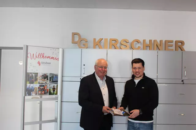 Bürgermeister Tony Löffler überreicht Maximilian Kirschner eine Ubstadt-Weiher Uhr und ein Bildband